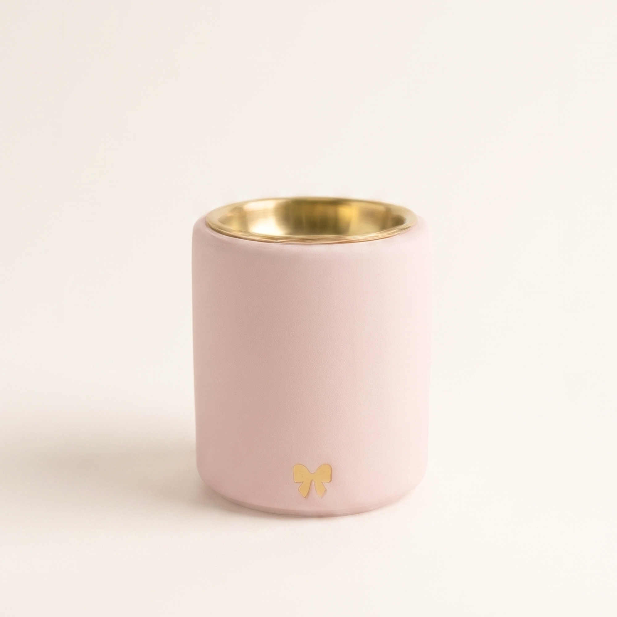 Handmade blush pink Loesieloe wax melt burner made from cast porcelain plaster with golden dish and small bow detail.