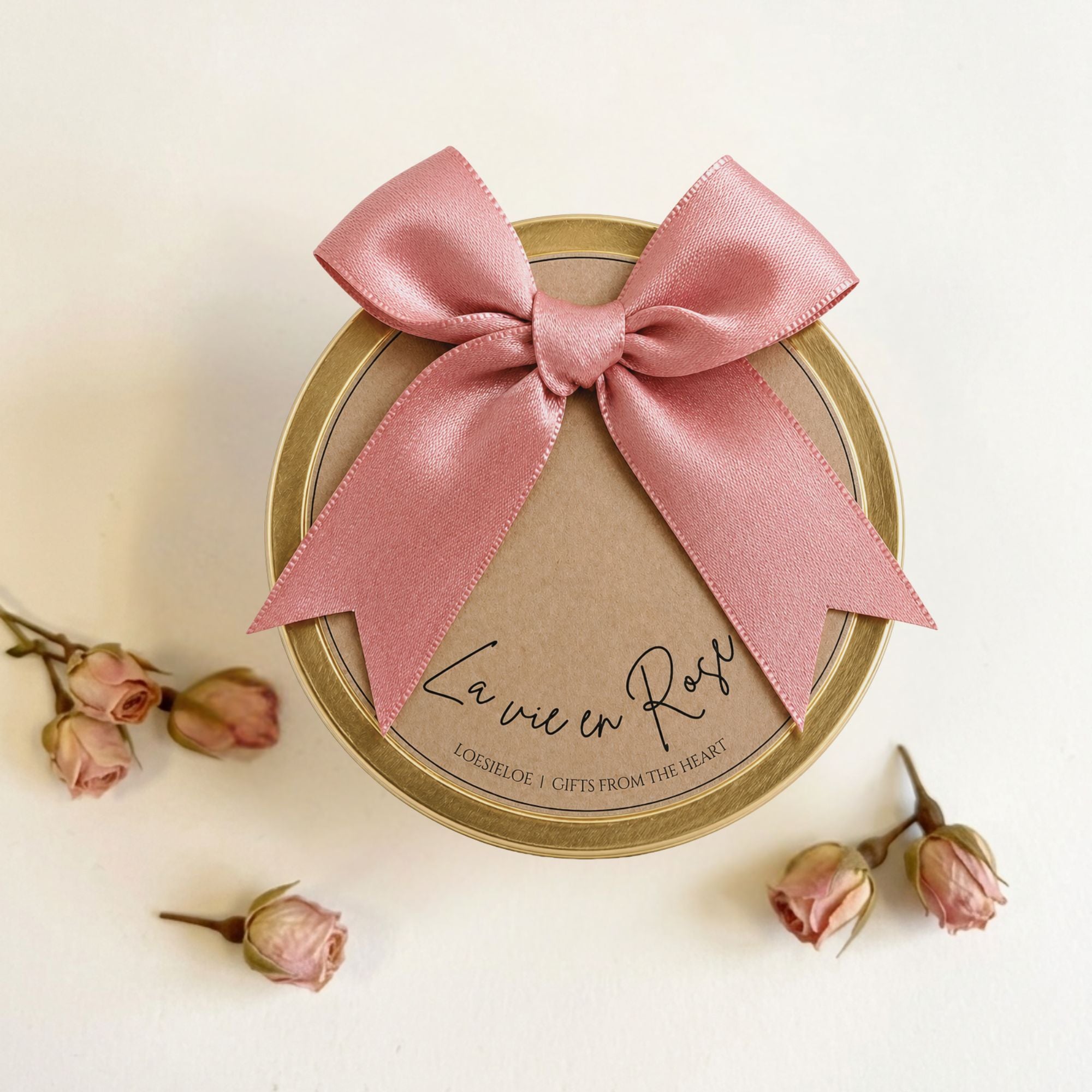 La Vie en Rose Golden Floral Candle made from natural soy wax in a golden candle tin with a soft pink bow and soft floral scent. La Vie en Rose Golden Floral Candle van natuurlijke sojawas in gouden candle tin met roze strik en zachte bloemige geur.

