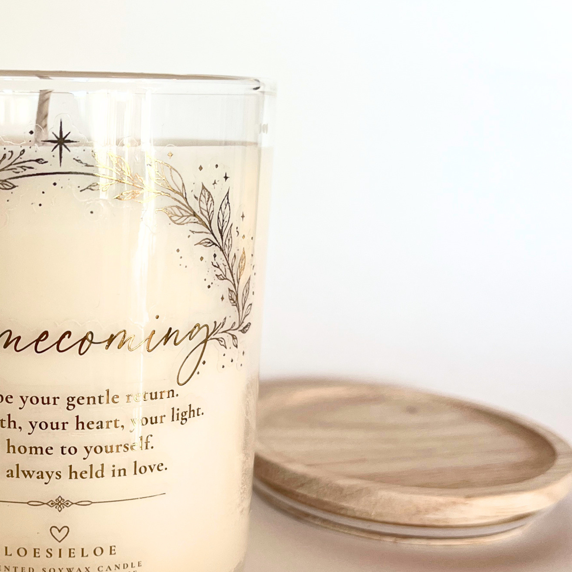 Homecoming scented candle in a glass jar with wooden lid and a warm fragrance of vanilla and cinnamon.
